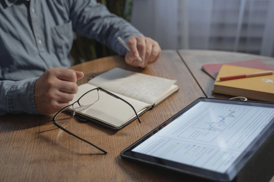 Stratég píšící poznámky do zápisníku během porady